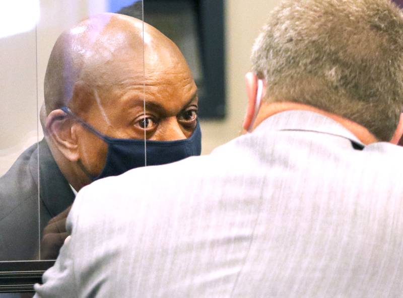 Shawn Thrower (left) talks to his attorney Liam Dixon Thursday through an opening in the plexiglass divider used to help prevent the spread of COVID-19 at the DeKalb County Courthouse during his trial for battery against an employee at his business, Shawn's Coffee Shop, in Sycamore. Thrower was found guilty of two counts of battery and a sentencing hearing will be held Nov. 13.