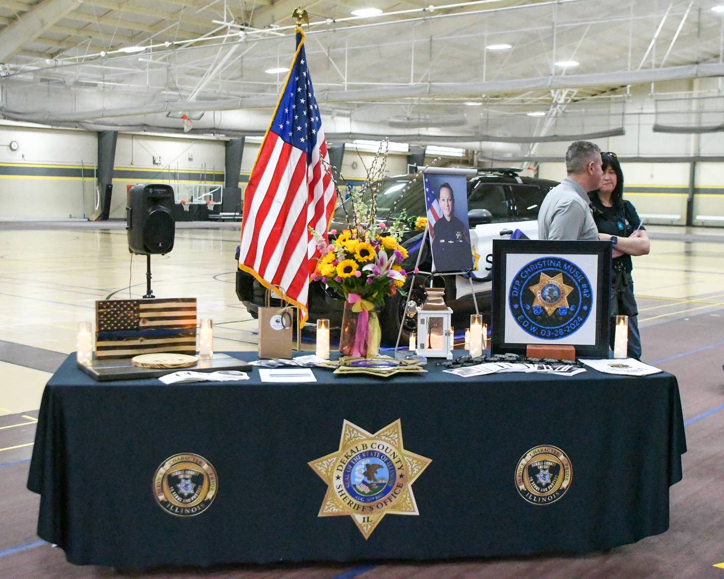 Items are displayed on a table on Saturday, March 29, 2025, during a memorial vigil to mark one year since the late DeKalb County sheriff's deputy Christina Musil, 35, was killed in the line of duty in a rear-end car crash in Waterman while on patrol on March 28, 2024.