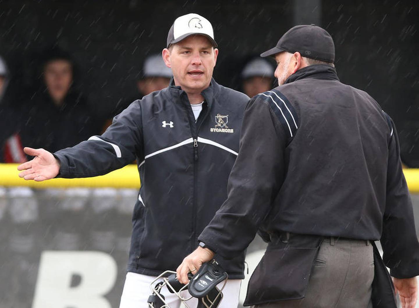 Sycamore baseball head coach Jason Cavanaugh argues a call as the rain comes down during their game against DeKalb Thursday at the Sycamore Community Sports Complex.