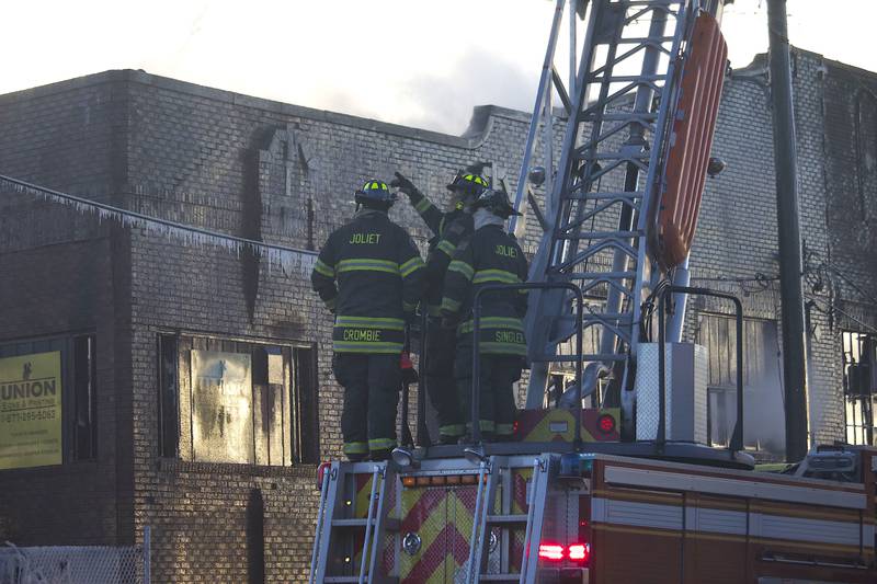 Joliet firefighters at the scene of a fire at an old commercial building on Thursday, Jan. 29, 2026, at the corner of South Eastern Avenue and Washington Street in Joliet.