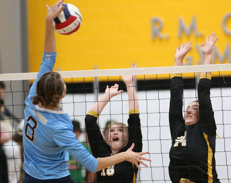 Marquette's Mary Lechtenberg spikes the ball past Putnam County's Salina Breckenridge and Maggis Richetta on Thursday, Sept 7, 2023 at Putnam County High School.