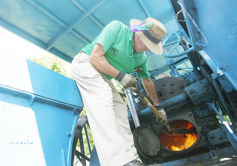 Les Petersen, 70, of Hampshire, shovels coal into the furnace of his 1925 Baker 21-75 horsepower on Thursday, August 14, 2014, at the Northern Illinois Steam Power Club's Steam Show and Threshing Bee at Taylor Marshall Farm in Sycamore.  Petersen was getting ready for the parade where he was pulling a thresher.  He said he's  been to every Steam Show and Threshing Bee except in 1966 when he was in the army.