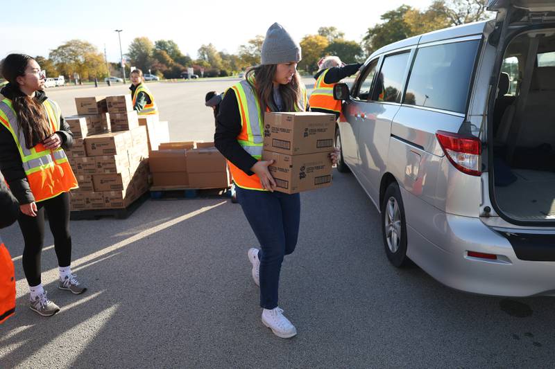 Volunteer Janelly Plascenca loads groceries into a van at Joliet Junior College on Saturday, Oct. 21. With inflation and rising food costs, Northern Illinois Food Bank held a Free PopUp Grocery Distribution giving away groceries to 700 families.