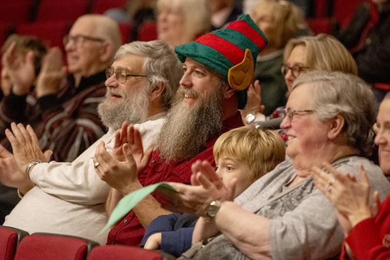 Sam Coussens (elf hat) applauds his daughter who was one of the performers on stage during the TubaChristmas concert on December 15, 2024 at Hall High School.