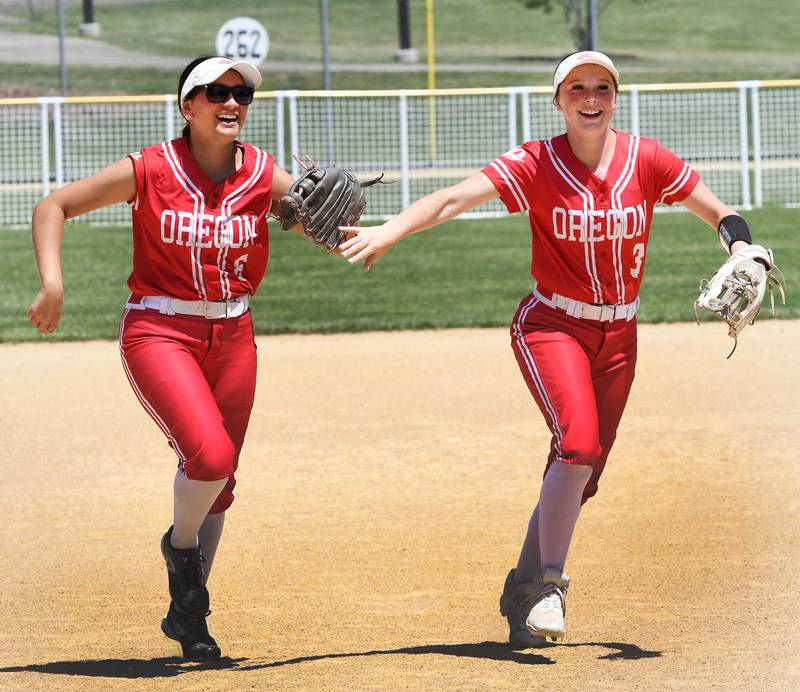 Oregon outfielders Giselle Zavala (left) and Avery Young smile after making an out against Rock Falls in the championship game of the 2A Oregon Regional on Saturday, May 23, 2026 at Oregon Park West.