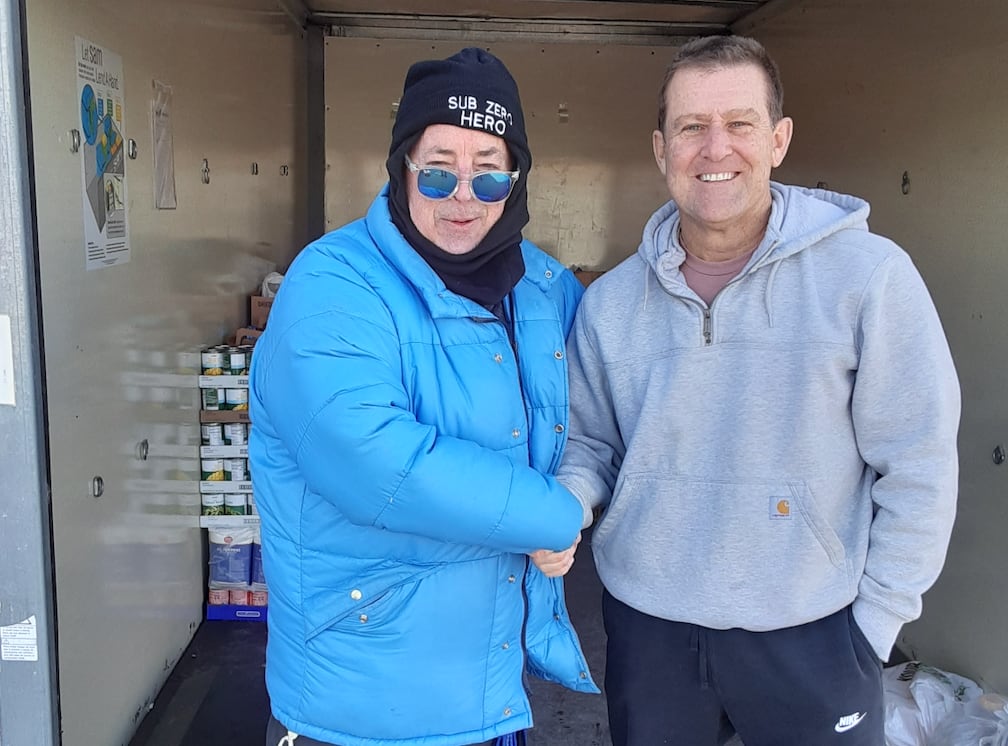 Former DeKalb radio host turned podcaster TD Ryan (left) poses with former Sycamore Police Chief Jim Winters, now retired, on Friday, Dec. 5, 2025, at Ryan's annual Freezin' For Food collection drive in the parking lot of Hy-Vee in Sycamore. The collection raises funds and donations for The Salvation Army to help feed families this holiday season.