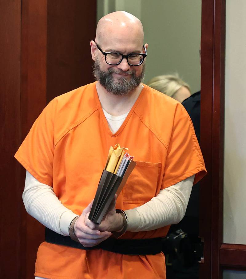 Jonathan D. Hurst, convicted of murdering Sycamore mother and son Patricia and Robert Wilson in 2016, smiles at members of his family as he enters the courtroom Thursday, March 20, 2025, for his sentencing at the DeKalb County Courthouse in Sycamore. Hurst was sentenced to life in prison.