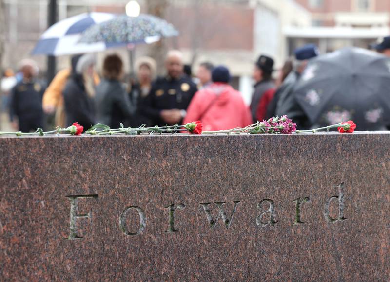 People gather Tuesday, Feb. 14, 2023, at the memorial outside Cole Hall at Northern Illinois University for the victims of the mass shooting in 2008 during a remembrance ceremony. Tuesday marked the 15th year since the deadly shooting took place on campus which took the lives of five people.