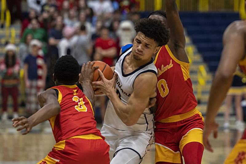 Sterling’s Andre Klaver splits the defense of Rock Island Tuesday, Dec. 5, 2023 at Sterling High School.