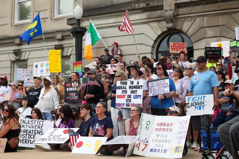Protesters hold signs and applaud speakers as approximately 500 people gathered for a photo on the steps of the Kankakee County Courthouse during a ‘No Kings’ rally in Kankakee on Saturday, June 14, 2025, to protest actions by President Donald Trump.