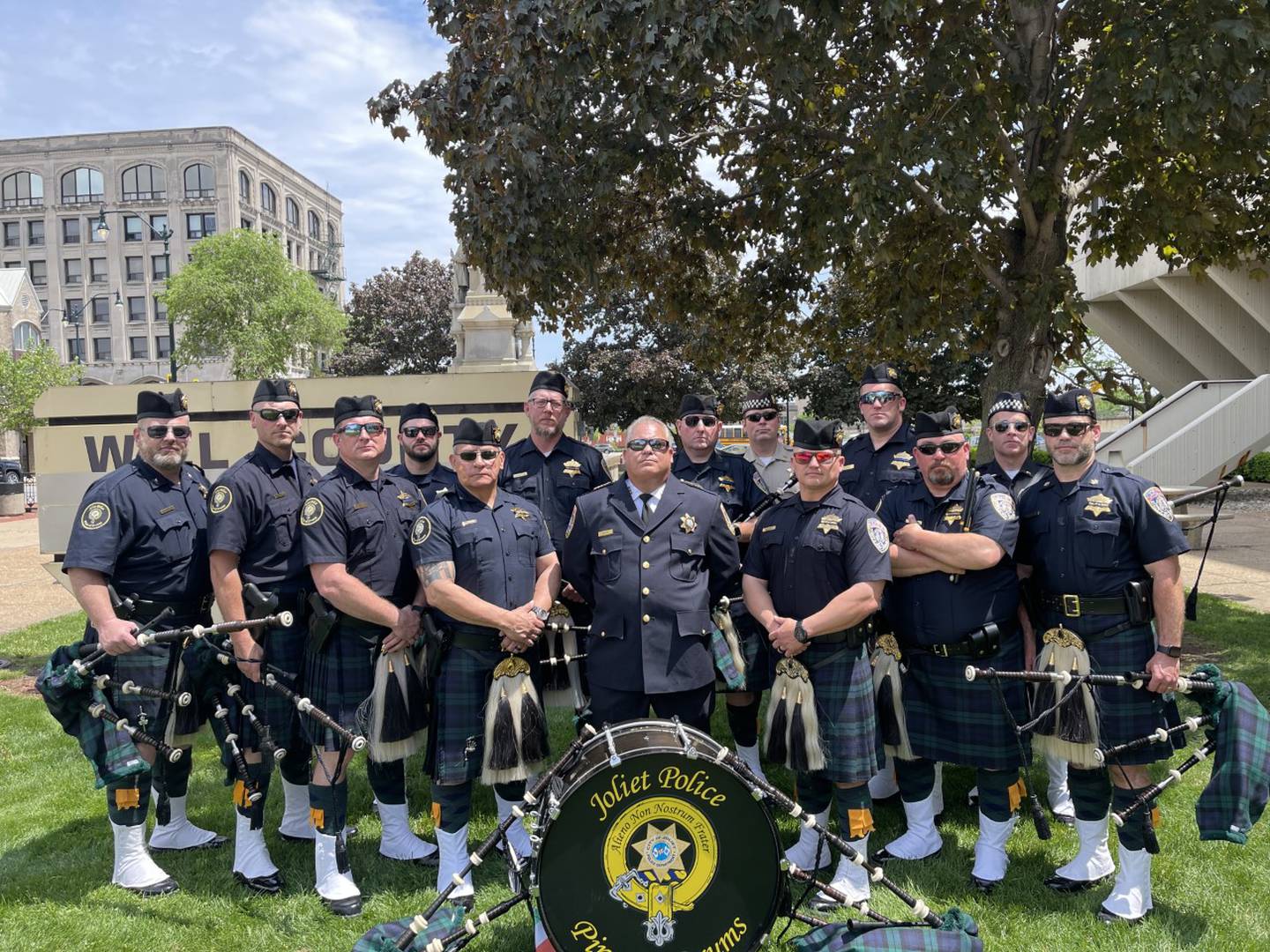 The Joliet Police Department Pipe and Drum Band poses for a photo outside the old Will County Courthouse.