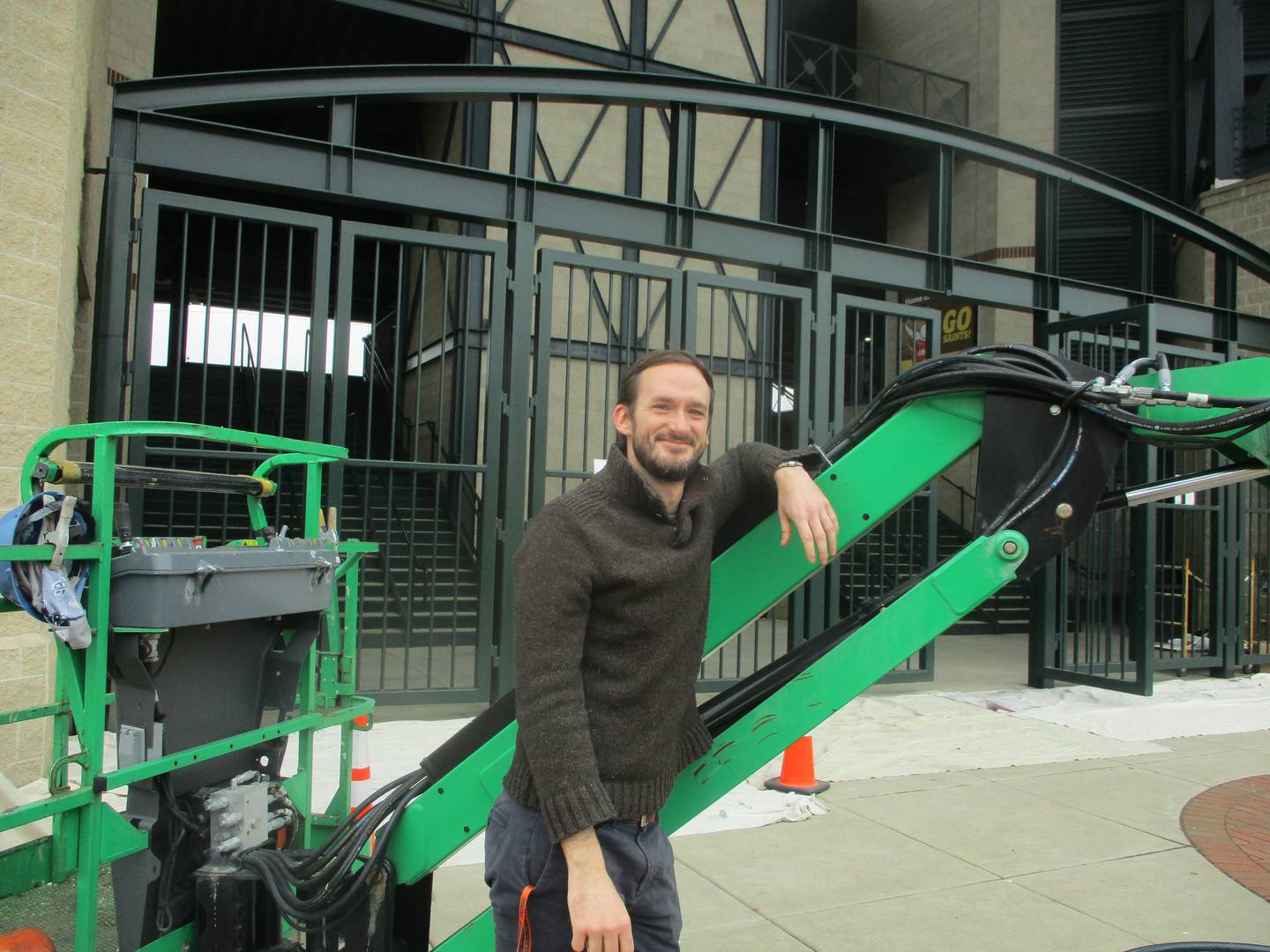 Joliet Slammers Executive Vice President Night Train Veeck poses for a photo in front of construction equipment at Slammers Stadium. April 10, 2025