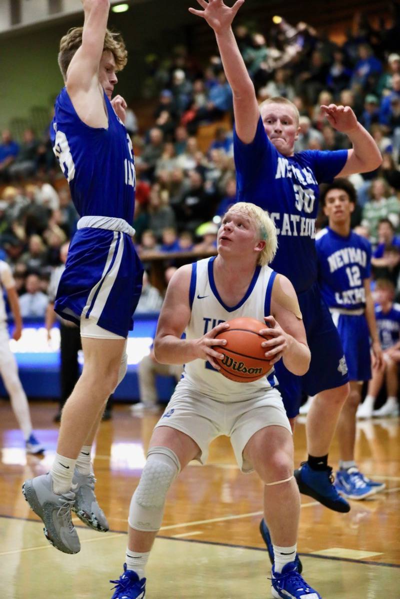 Princeton's Daniel Sousa finds what goes up must come down as Newman's Lucas Simpson and Dax Snyder go airborne Tuesday at Prouty Gym. The Tigers won 59-54.