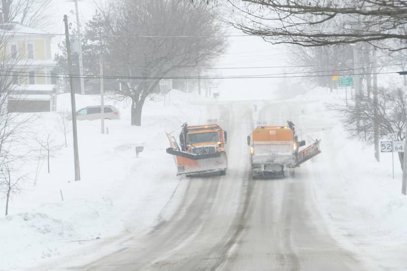 Two Illinois Department of Transportation snow plows pass each other near Illinois 64 in Lanark on Saturday. Snow and wind out of the north made for drifting along east-west roads.