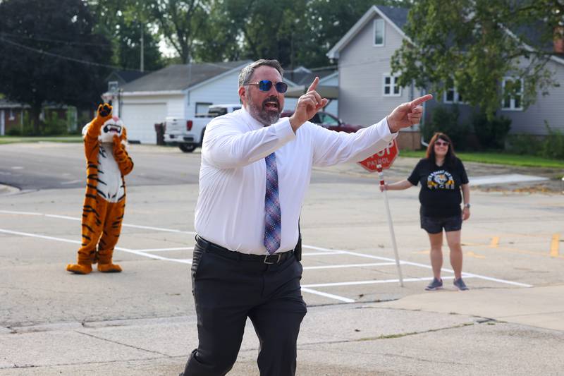 As the last group of students arrived, Herscher Intermediate School principal Brett Miller shouts for everyone to have a great school year on Tuesday, Aug. 19, 2025, as the first day of school began.