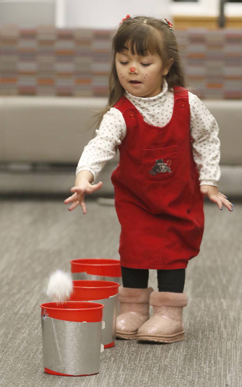 Lanna Murphy, 3, of Crystal Lake, tosses a snowball Friday, Dec. 2, 2022, during the Very Merry Huntley Holiday Open House at the Huntley Area Public Library. The event featured musical entertainment by Andy Huber, reindeer, Santa, a scavenger hunt, face painting, and a snowball toss.