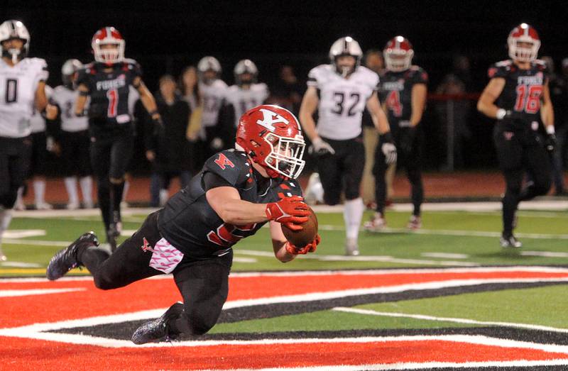 Yorkville running back Benjamin Alvarez (5) makes a diving catch for a first down against the Plainfield North defense during a varsity football game at Yorkville High School on Friday, Oct. 20, 2023.