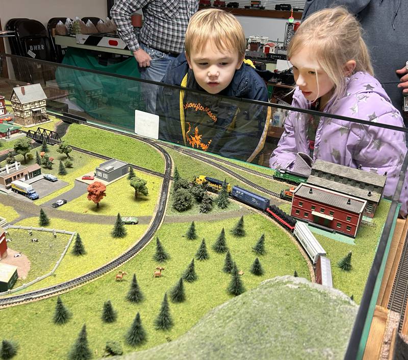 Brielynn Grote, 7, and her brother,  Jase, 3, of Oregon, watch a model train at the Blackhawk Model Train Club in Conover Square Mall during Oregon's Candlelight Walk on Saturday, Dec. 6, 2025.