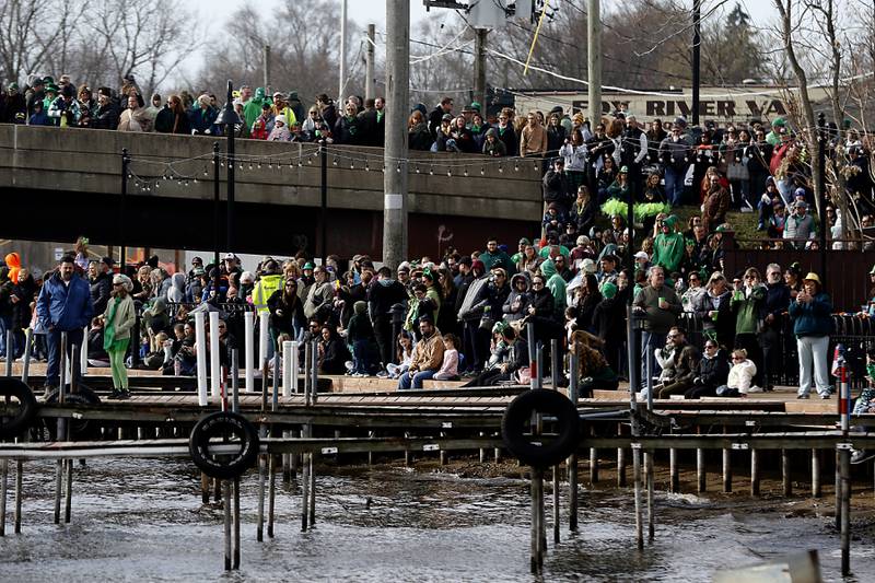 People watch as the Fox River is dyed green during the ShamROCKS the Fox Festival in McHenry on Saturday, March 16, 2024.