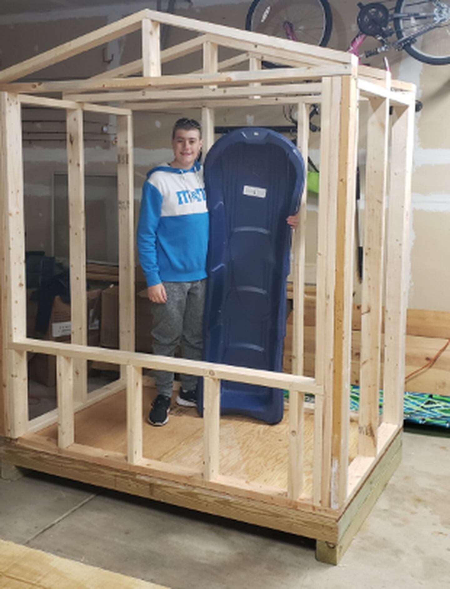 Genoa Boy Scout Jacob Reiss poses next to an in-progress community sled shed he built as part of his Eagle Award project. The completed shed is at Russell Woods Forest Preserve and the sleds are available to all.