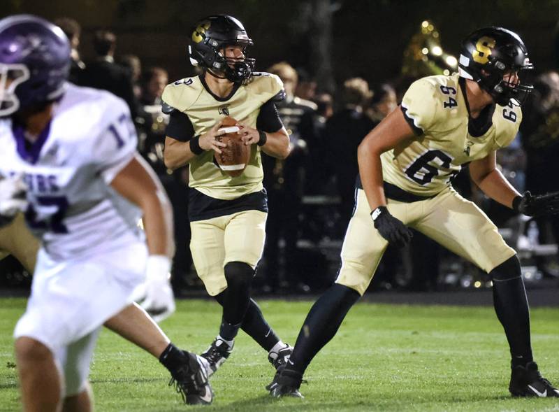 Sycamore's Griffin Larsen looks for a receiver during their game against Rochelle Friday, Sept. 19, 2025, at Sycamore High School.