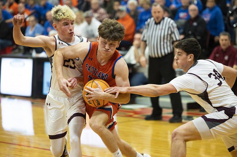 Eastland’s Braden Anderson drives to the hoop against Dakota’s Liam Burke (left) and Cason Mayer Wednesday, March 4, 2026, in the Orion 1A sectional semifinal.