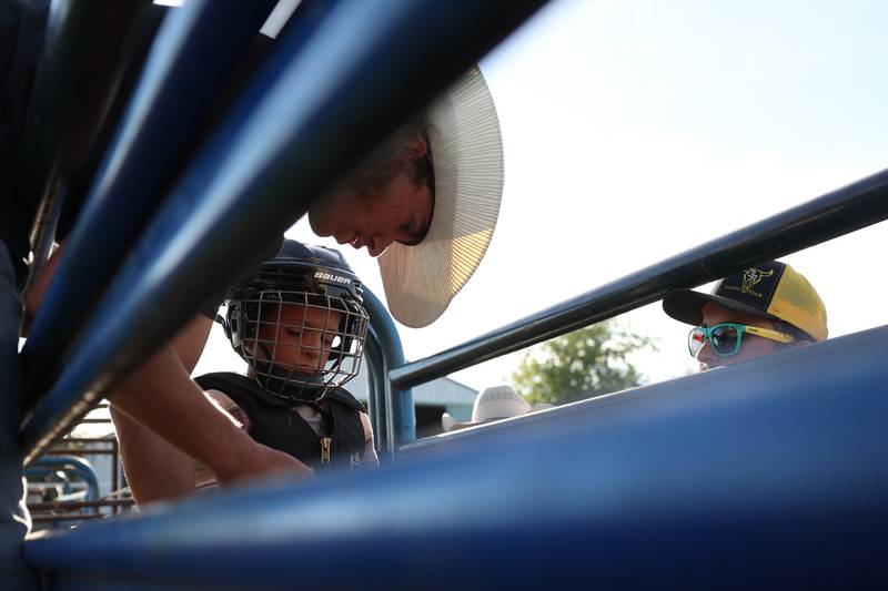 Dominic Dubberstine-Ellerbrock helps Wyatt Plese prepare for his bull ride. Dominic will be competing in the 2022 National High School Finals Rodeo Bull Riding event on July 17th through the 23rd in Wyoming. Thursday, June 30, 2022 in Grand Ridge.