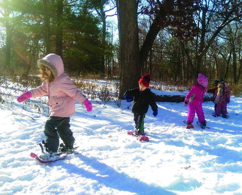 Children slide through the snow during a Downers Grove Park District winter event. The district offers ice skating at Prince Pond as well as sledding and snow shoeing at Lyman Woods.