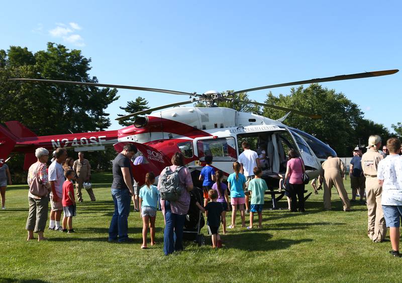 Families and kids check out the OSF life flight helicopter at the National Night Out in Princeton at Alexander Park on Tuesday Aug. 3, 2021. The event featured K-9 and drone demonstrations, face painting, hot dogs, fingerprinting, car seat safety checks, tours of emergency vehicles and life flight helicopter.