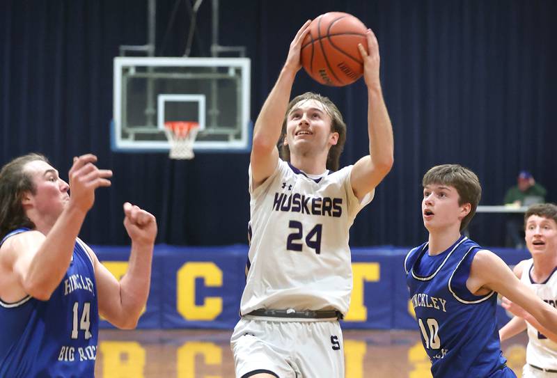 Serena's Camden Figgins drives between Hinckley-Big Rock's Martin Ledbetter (left) and Max Hintzsche Friday, Feb. 3, 2023, during the championship game of the Little 10 Conference Basketball Tournament at Somonauk High School.