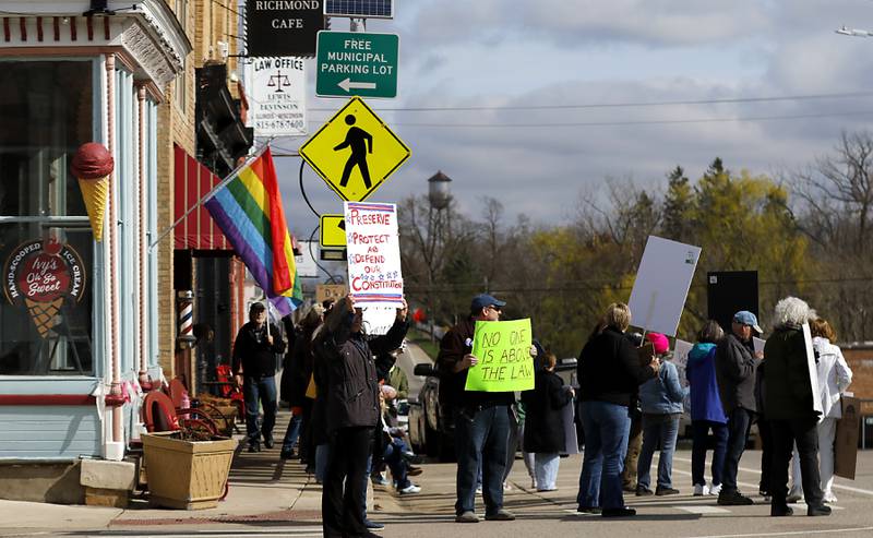 Protesters line U.S. Route 12 in Richmond to protest their discontent with President Donald Trump and his administration's policies on Saturday, April 19, 2025. Over 100, people took part in the Richmond protest. A second rally was held in Harvard later in the day.