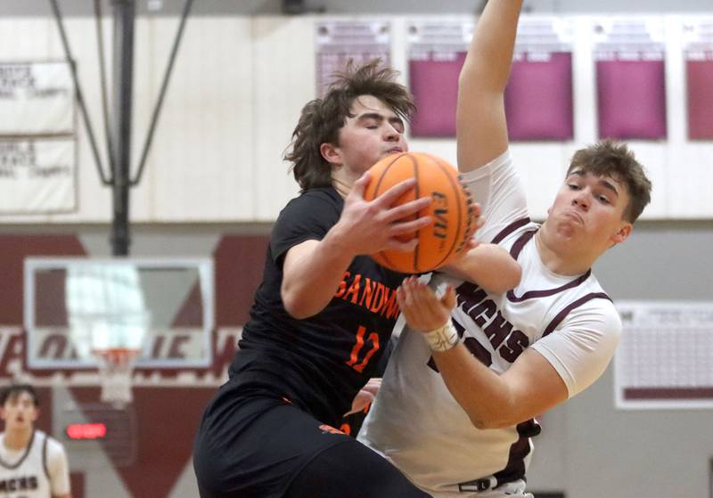 Sandwich’s Charles Behringer, left, works under the hoop against Marengo’s Sam Vandello in varsity boys basketball action on Saturday, Jan..24, 2025, at Marengo High School in Marengo.