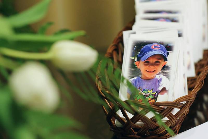 Prayer cards for AJ Freund, 5, sit on a table next to the visitor guestbook May 3, 2019, at Davenport Funeral Home in Crystal Lake.