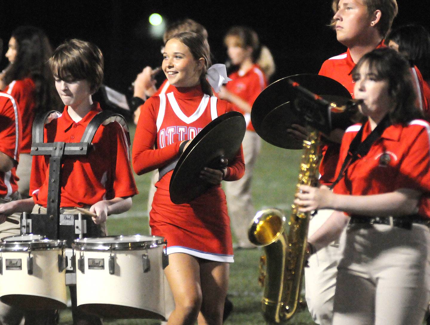 Ottawa cheerleader Chloe Carmona performs on cymbals with the marching band at halftime at King Field on Friday, Sept. 8, 2023.