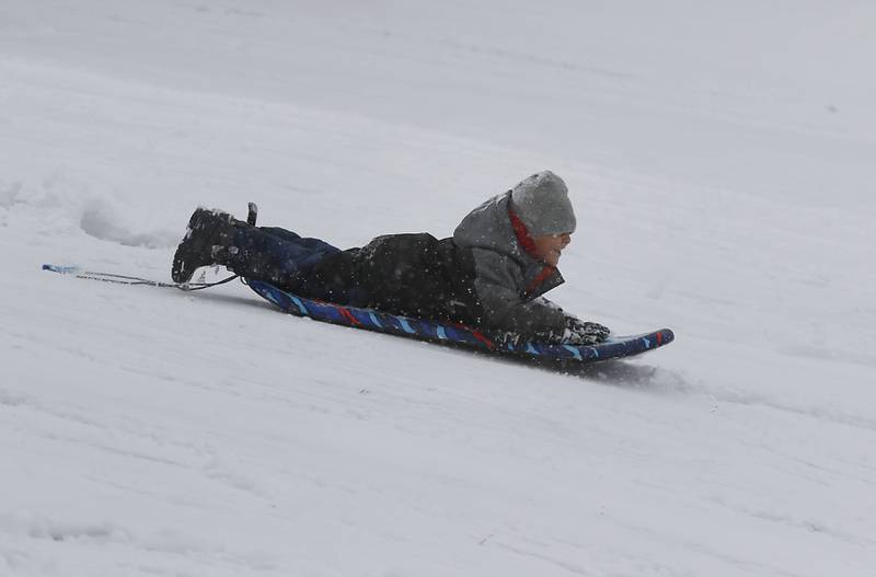Javi Domingo, 6, of Cary, flies down a hill Wednesday, Jan. 25, 2023, while sledding with other children at Veteran Acres Park in Crystal Lake. Snow fell throughout the morning, leaving a fresh blanket of snow in McHenry County.