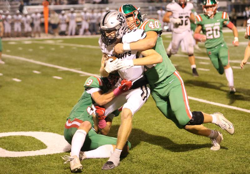 Kaneland's Jalen Grabowski is brought down by L-P's Jaron Morscheiser and teammate Nick Hachenberger on Friday, Oct. 17, 2025 at Howard Fellows Stadium.