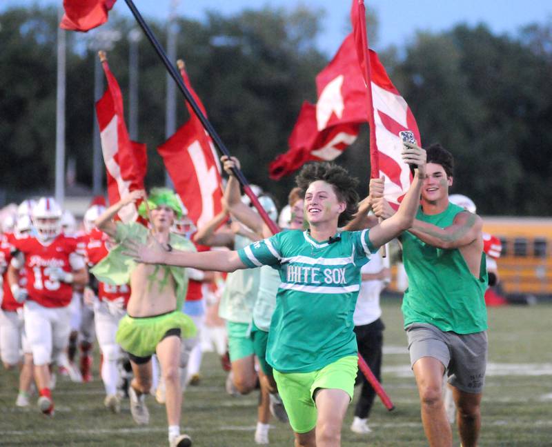 Ottawa super fans escort the football team onto the field before the home game against Streator at King Field on Friday, Sept. 1, 2023.
