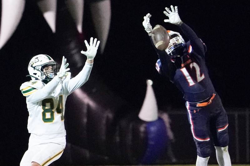Oswego’s Mariano Velasco (12) deflects a pass intended for Waubonsie Valley's Gavin Ali Hanlon (84) during a Class 8A first-round playoff game at Oswego High School on Friday, Nov. 1, 2024.