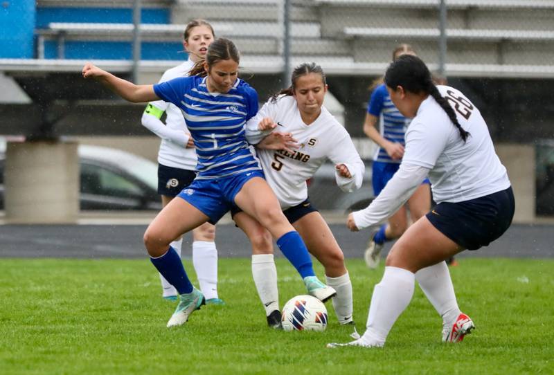 Princeton's Olivia Sandoval battles Sterling's Tatiana Ibarra (5) and Michelle Diaz (26) for the. ball Thursday at Bryant Field. The Tigresses prevailed over the Golden Warriors and rain for a 3-1 victory.