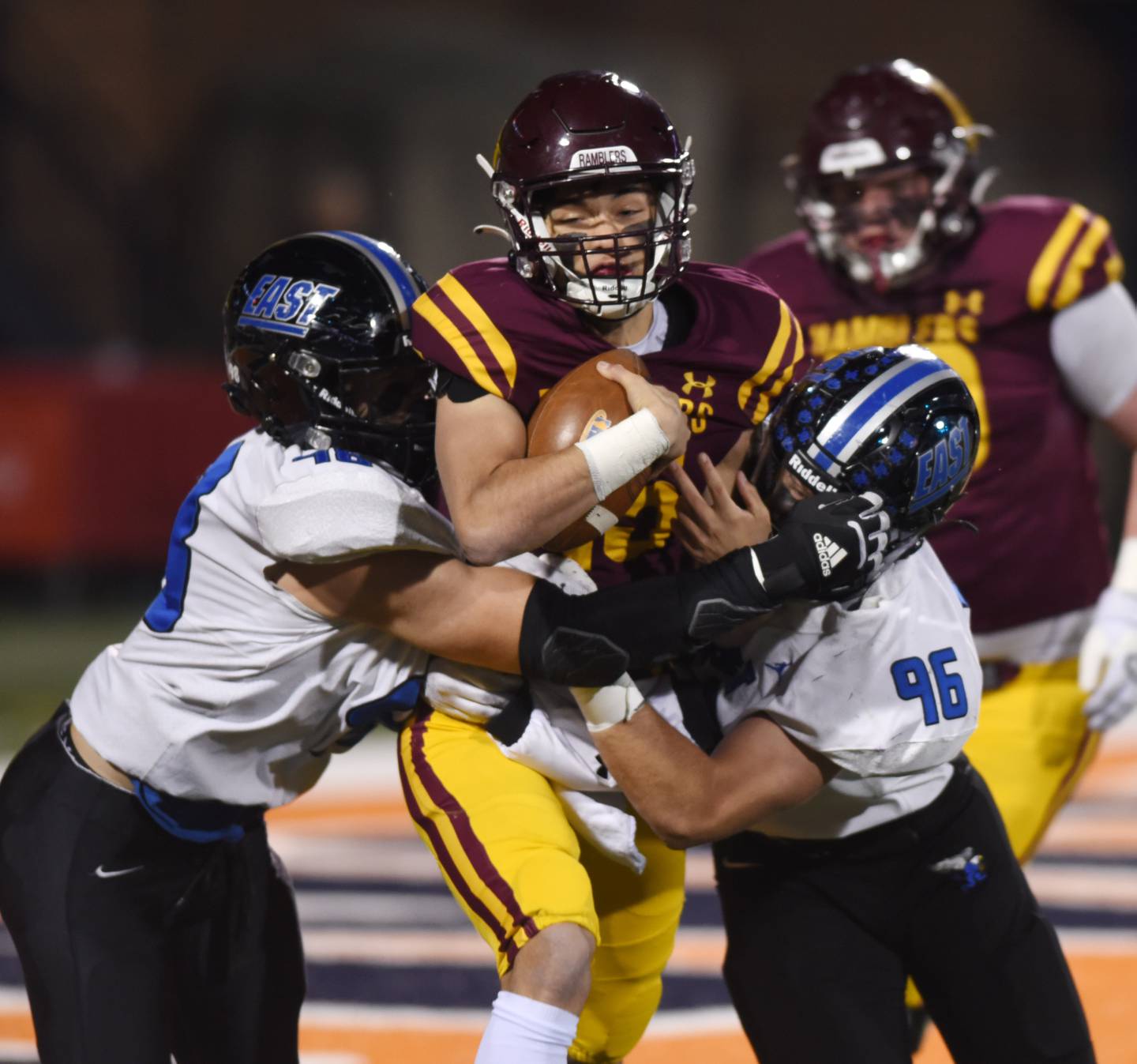 Loyola Academy quarterback Jake Stearney, middle, gets tackled by Lincoln-Way East's Joe Fushi, left, and Hank Ravetto during the Class 8A football state title game at Memorial Stadium in Champaign on Saturday, Nov. 26, 2022.