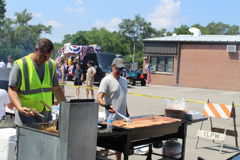 Volunteers cook up french fries and hot dogs at the Island Lake July 4 picnic on July 4, 2023.