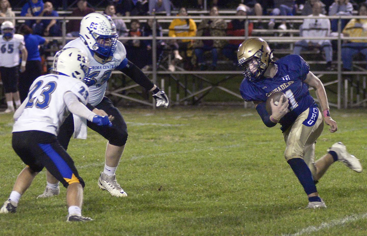 Marquette’s Anthony Couch works to get past Aurora Central Catholic’s Aiden Crisco and Charlie Anderson on a first-quarter run in Ottawa.