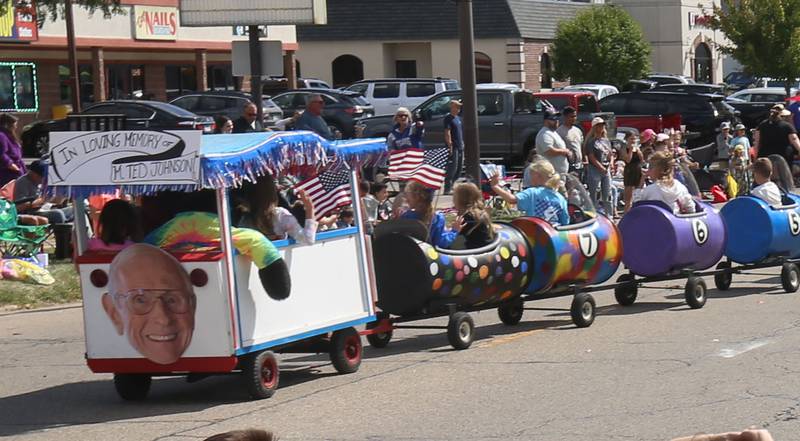 A sign reads "in loving memory of Ted Johnson on the back of colorful barrels during the 54th annual Homestead Festival parade on Saturday, Sept. 6, 2025 in Princeton. Ted Johnson, drove the waggons for a number of years, passed away ealier this year.