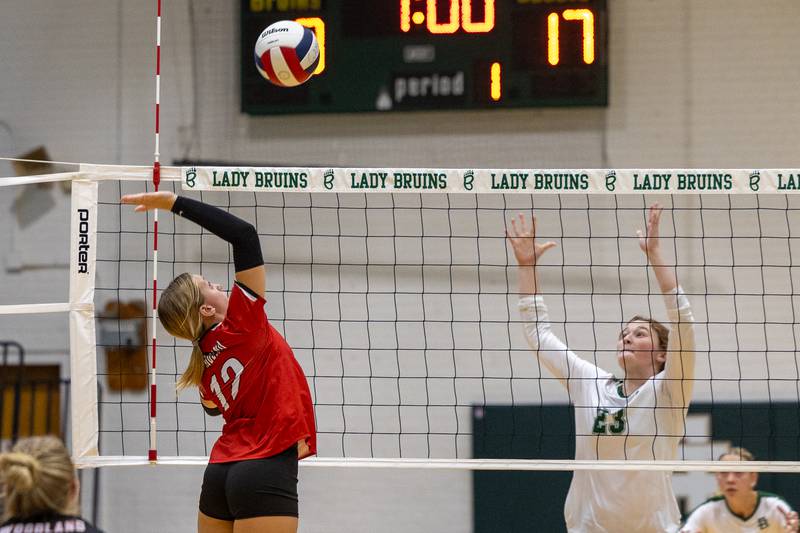 Sydney Wright (12) of Woodland attacks ball over net as Lili McClain (23) of St. Bede jumps to its defense on Thursday, Sept. 11, 2025 at Abbot Vincent Gymnasium in Peru.