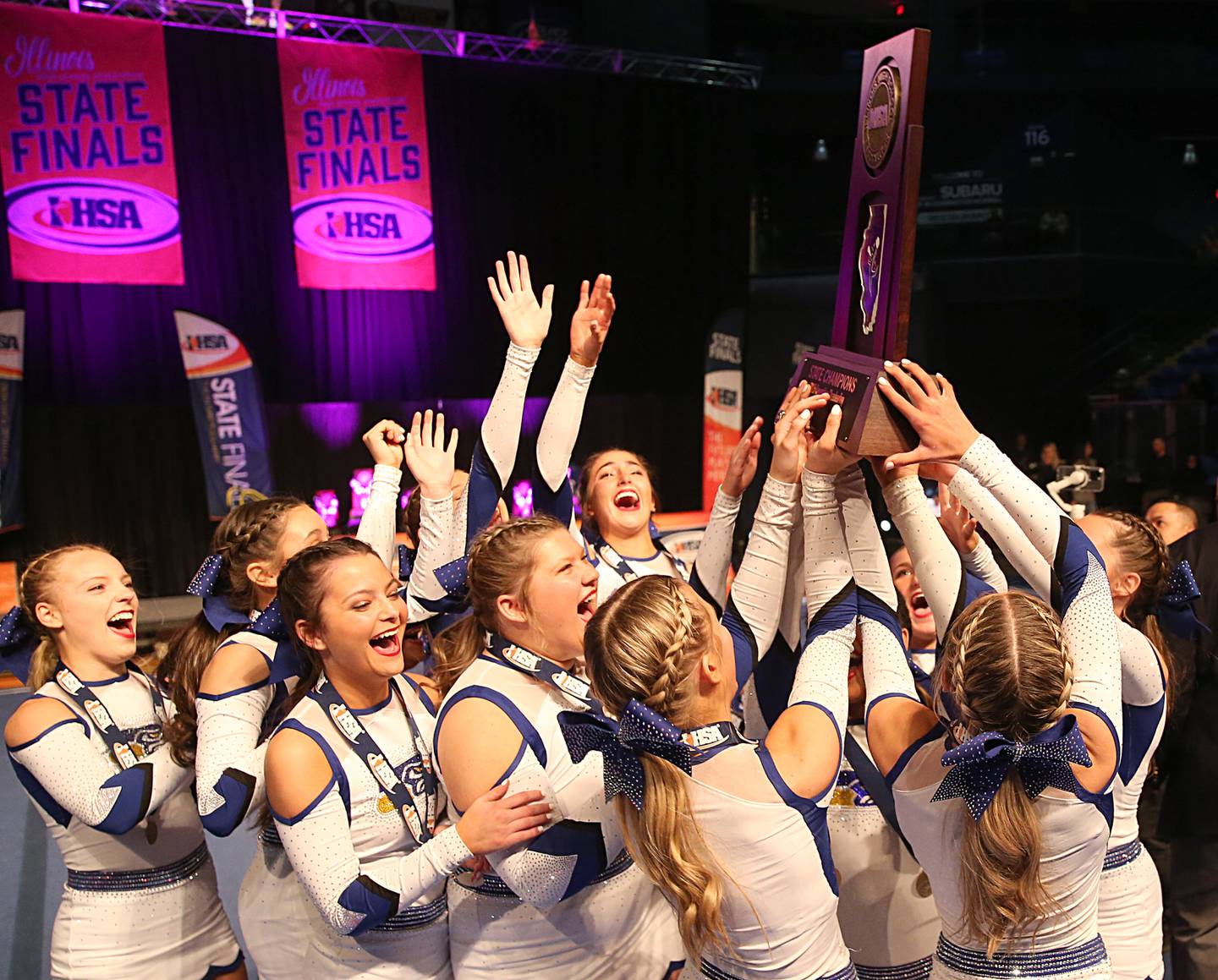 Members of the Johnsburg cheer team receive the first place trophy during the IHSA Cheer State Finals in Grossinger Motors Arena on Saturday, Feb. 4, 2023 in Bloomington.