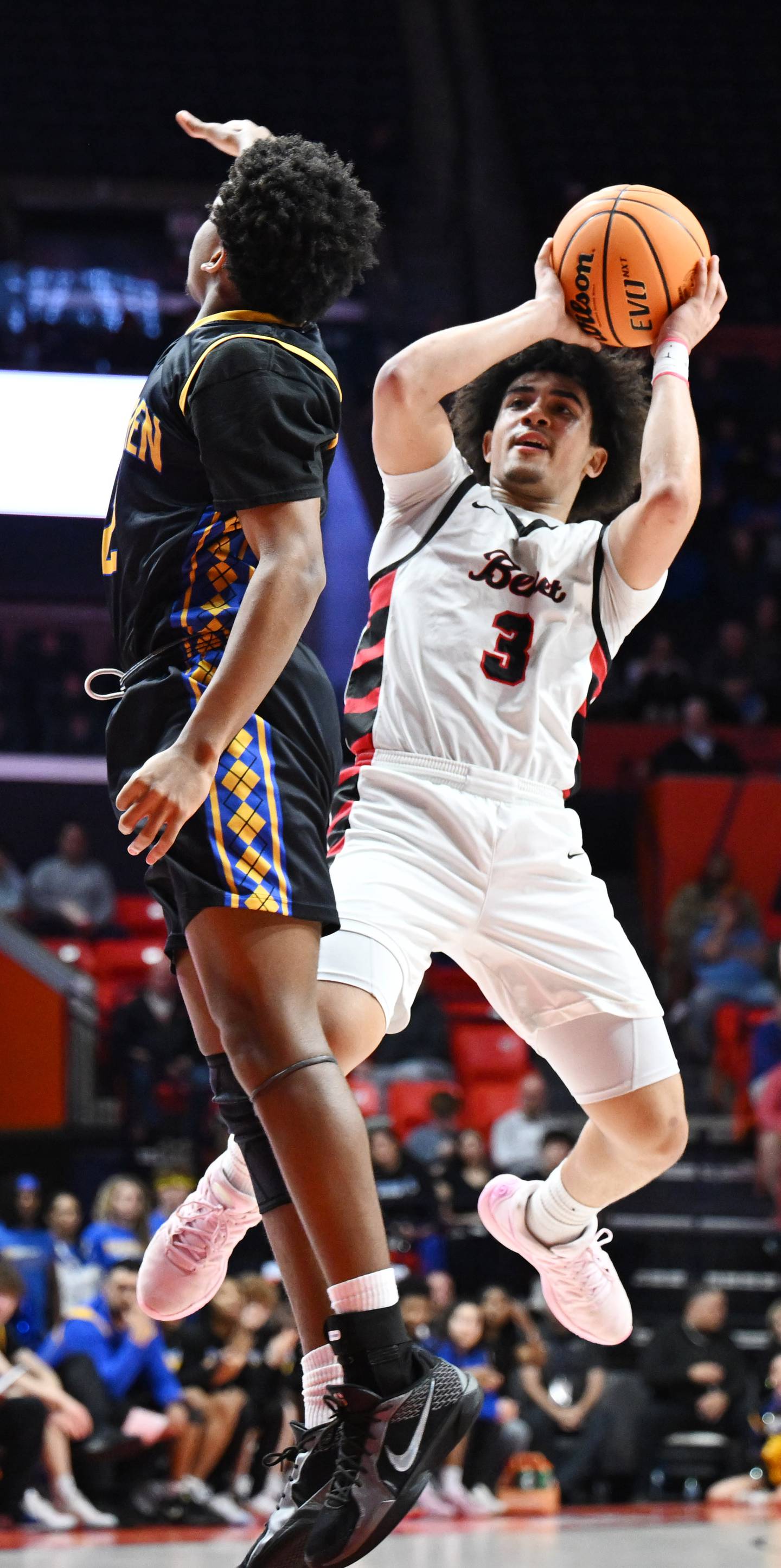 Benet Academy's Ryan Walsh, right, delays the release of his shot just long enough for Warren's Andrew Watson to clear his line of vision during the IHSA Class 4A boys basketball state championship game at State Farm Center on Saturday, March 15, 2025 in Champaign.