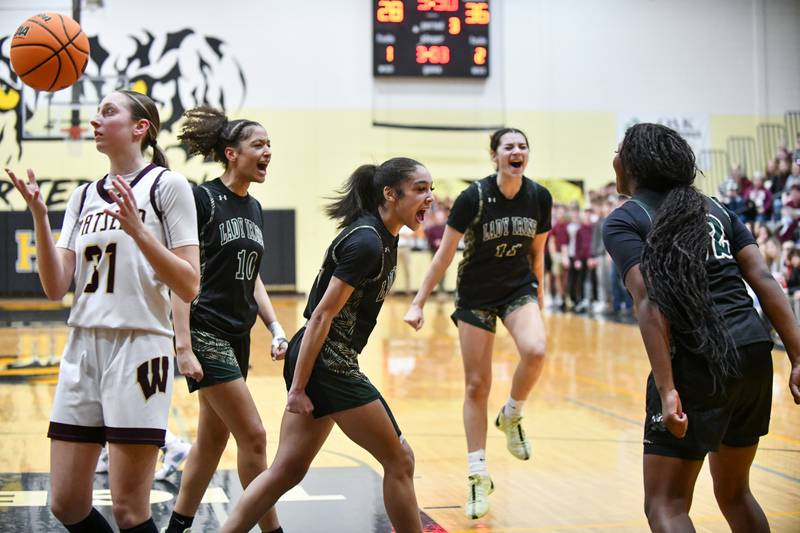 Bishop McNamara's Jaide Burse, center, Trinitee Thompson (10) and Trinity Davis (11) celebrate a drawn foul by teammate Leigha Brown, right, during the Fightin' Irish's 69-38 victory over Watseka-Milford in the IHSA Class 2A Herscher Sectional championship on Thursday, Feb. 27.