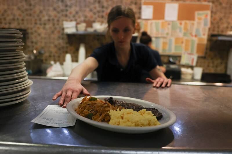 Waitress Bree McDonald picks up an order at Tasty Waffle in Romeoville.