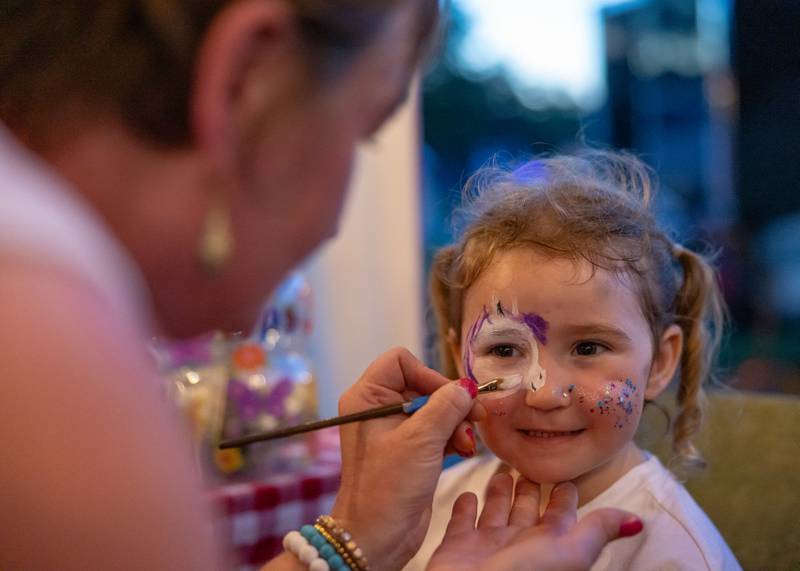 Sadie Kman gets her face painted by one of the vendors that were stationed near the baseball diamond before the start of the Mendota fireworks on June 28, 2025 in Mendota.