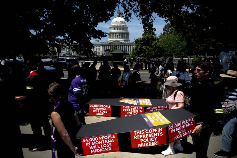 Demonstrators carry cardboard caskets in front of the U.S. Capitol in protest of President Donald Trump's tax breaks and spending cuts package, Monday, June 30, 2025, in Washington.